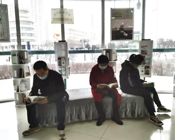 到银行办业务的市民阅读图书