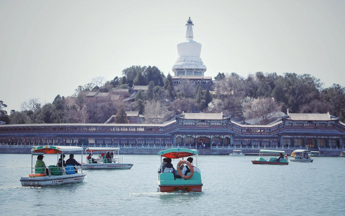 3月18日，北海公园，游船驶过白塔。新京报记者 薛珺 摄