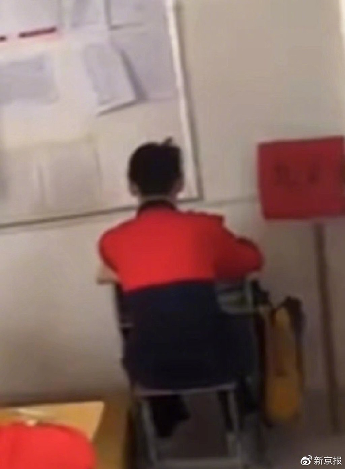 网传一学生被罚对墙坐。  网络视频截图