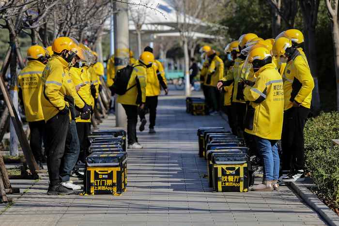 ↑2023年3月13日，山东潍坊，美团外卖骑手在召开例会。图据视觉中国