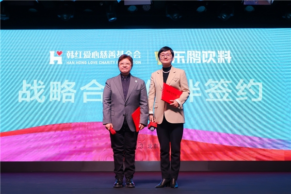 　　东鹏饮料集团副总裁蒋薇薇与韩红交换签约本