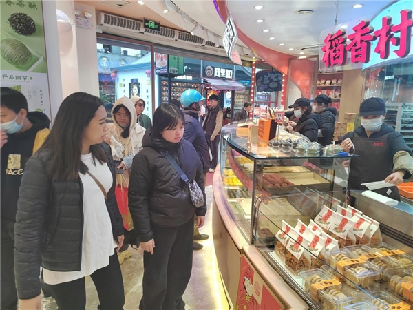 　　络绎不绝的食客排队购买稻香村糕点