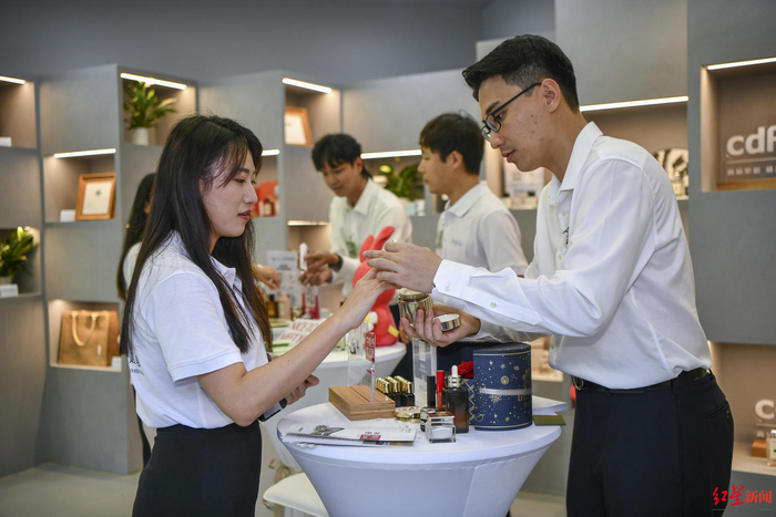 ↑2023年3月28日，海南琼海，工作人员向参观者介绍免税产品 据视觉中国