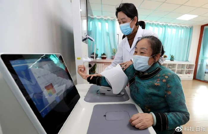 山东省东营市东营区黄河路街道玉景社区党群服务中心内，医护人员指导社区老人使用智能体检一体机自助查体。图源：视觉中国