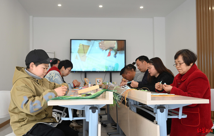 ▲成都市温江区，在残疾人文创灵活就业基地的残疾人正在手工制作衍纸工艺品