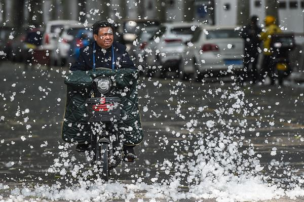 △太原，市民从大片飞絮中穿行而过。