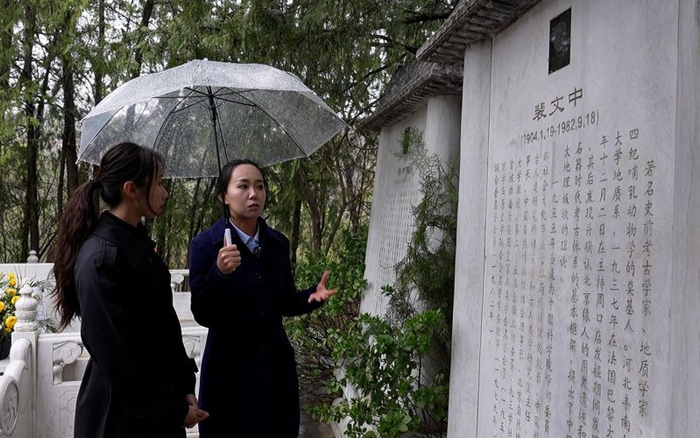 讲解员刘博（左二）向新京报记者（左一）讲述院士们的事迹。新京报记者 王巍 摄