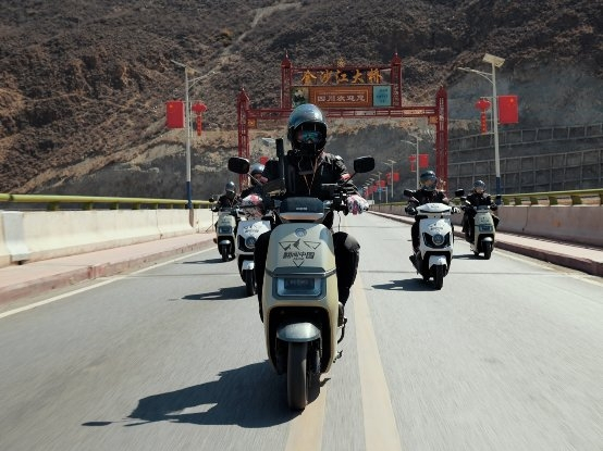 　　图:爱玛骑行车队行驶在金沙江大桥