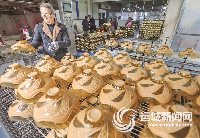 畖底镇玻璃加工厂工人在对新民玻璃出口乌兹别克斯坦的果斗进行烘烤。本报记者 金玉敏 摄