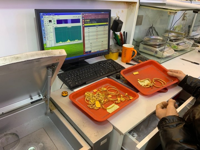  店铺工作人员用设备检测回收来的黄金纯度