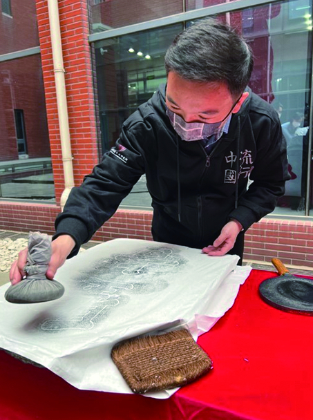 图为“法度与气象——在碑刻中遇见盛唐”展览开幕式上工作人员展示传拓技艺。 郑超 摄