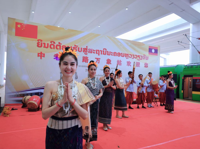 4月13日，在老挝万象站，工作人员欢迎乘坐D887次国际旅客列车的旅客。新华社记者 邢广利 摄