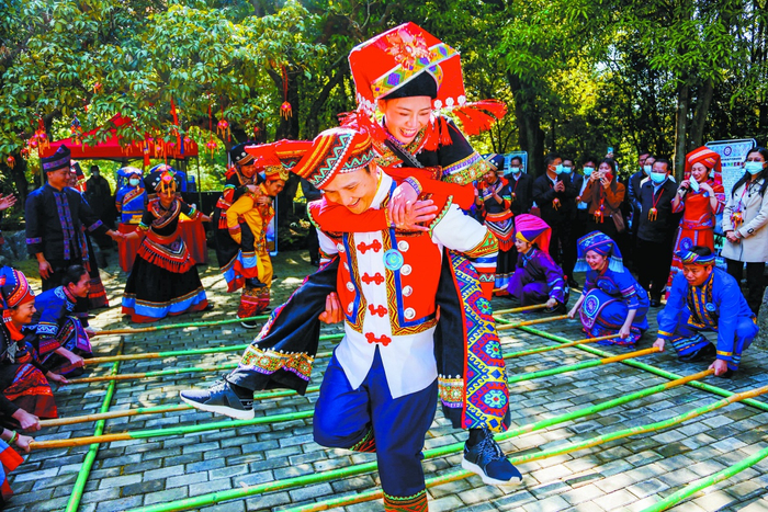 2022年南宁市武鸣区三月三活动现场，一位阿哥背着阿妹跳竹竿舞。记者 游拥军 摄