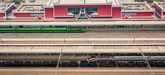 4月13日，“复兴号”（上）、“澜沧号”动车组列车停靠在中老铁路磨憨站（无人机照片）。新华社记者 胡超 摄