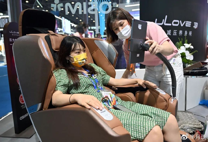 2022年7月28日第二届中国国际消费品博览会上，年轻的顾客在体验一款减压养生椅。郭程摄