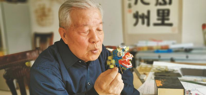 张天伟对着“微型动态龙”吹了一口气，龙头多个部位瞬间动起来。记者 武丹摄