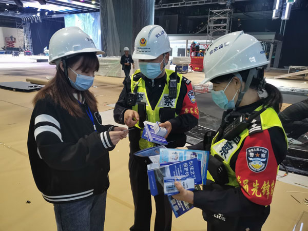 图说：警方给展位工作人员发放警民联系卡 警方供图（下同）
