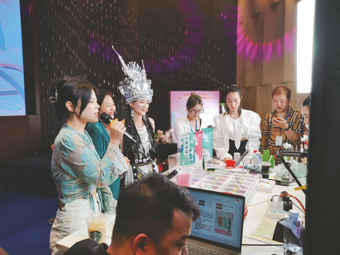 ▲多名主播身着少数民族传统服饰直播带货    本报记者 覃锦华 摄