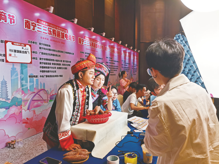 ▲多名主播身着少数民族传统服饰直播带货    本报记者 覃锦华 摄