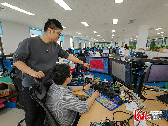 日前，保定飞凌研发中心经理宋明洋（左一）正与工作人员研讨设计方案。 河北日报记者 李连成摄