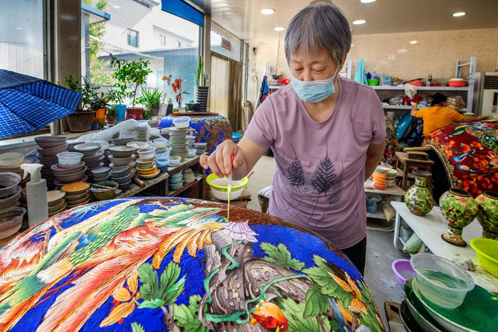 三河市燕郊镇南黄辛庄村景泰蓝生产车间内，工人正在点蓝。高澍摄