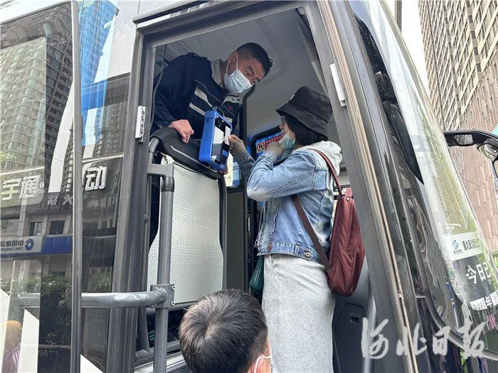 4月17日，在京津冀定制快巴三河市燕郊天洋城广场站，乘客正在刷身份证登车。通讯员高澍摄