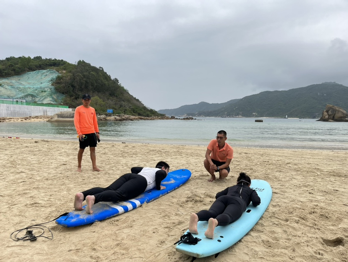 杨兴业正在向顾客讲解冲浪动作。记者 刘子榕摄