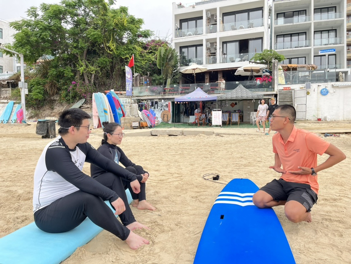 杨兴业正在向顾客讲解冲浪知识。记者 刘子榕摄