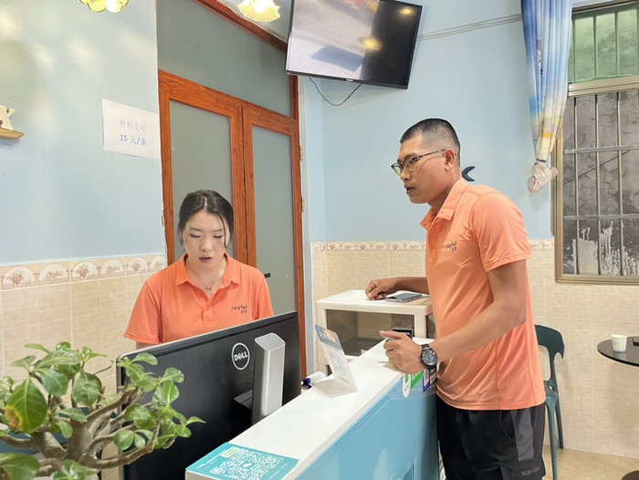 杨兴业和店员交流店铺经营情况。记者 刘子榕摄