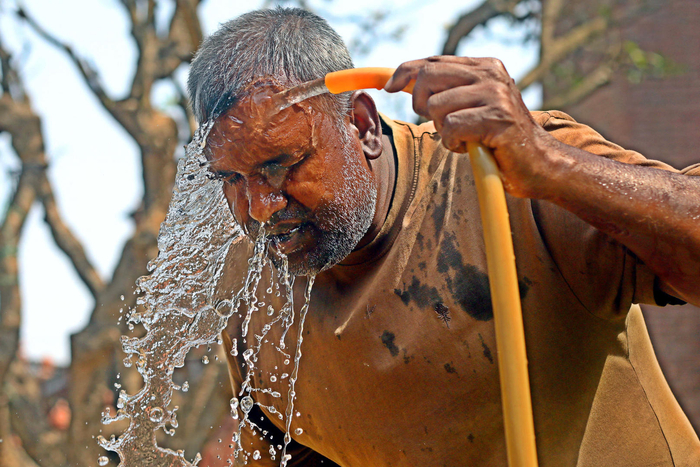 ↑孟加拉国达卡，当地迎来高温天气，市民拿起路边水管冲凉 图据IC photo