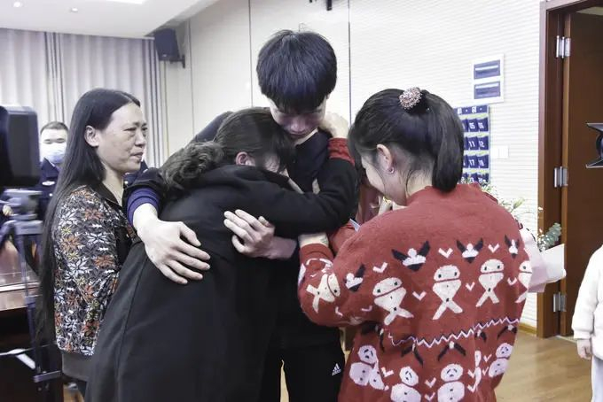2021年11月5日，浠水县群众徐小珍在团圆活动现场抱着失散22年的儿子痛哭，儿子细心地安慰母亲。（黄冈市公安局供图）