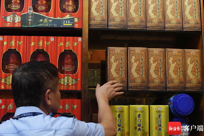 　　执法人员检查发现涉嫌侵权的白酒。记者 蒙健 摄