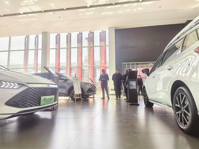     唐山一家知名汽车品牌4S店销售人员正向消费者介绍新能源汽车。  本报记者 杜雯拓 摄