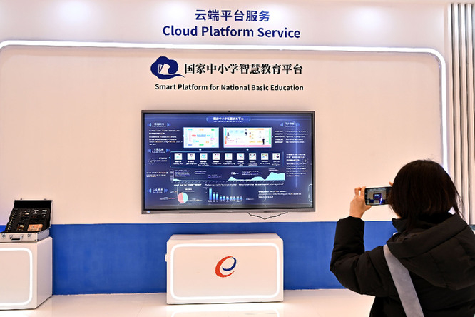 　　2月13日，世界数字教育大会在北京开幕，一名与会者在数字化教育装备应用展示区域参观拍摄。资料照片