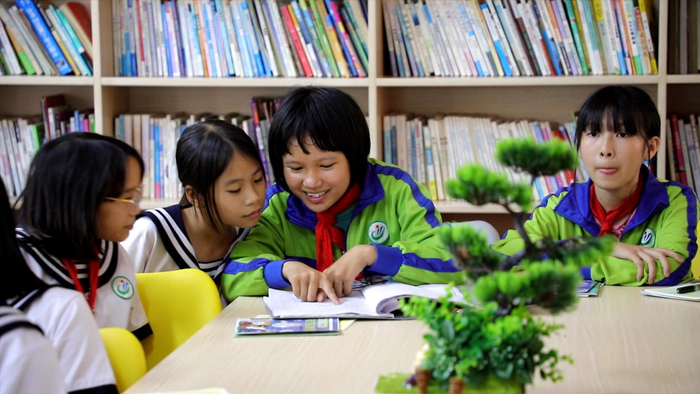 湛江市徐闻县角尾乡中心小学仕寮分校的学生在“南网知行书屋”阅读“蓝公益”志愿服务队志愿者带来的课外书