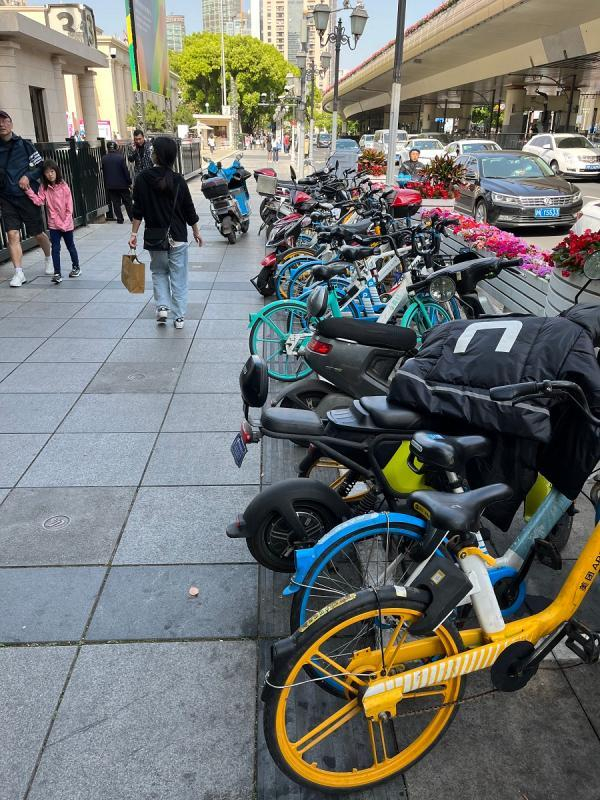 延安中路人行道上无障碍通道被停放的非机动车占据，还有非机动车在人行道通行