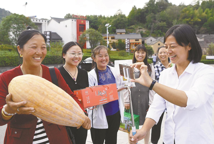 　　2022年9月26日，余静（右一）在拍摄过上小康生活的大湾村村民幸福的笑容。