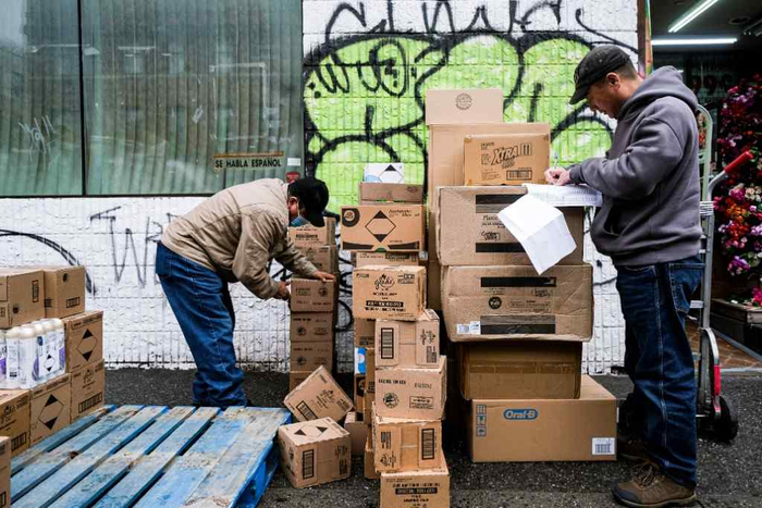 1月6日，两名工人在美国纽约一家商店门口卸货。新华社发（朱子于摄）