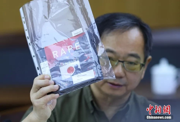 鲁照宁展示由美国音像公司发行的一套七张光盘的张纯如著作《南京浩劫：二战中被遗忘的大屠杀》。中新社记者 泱波 摄