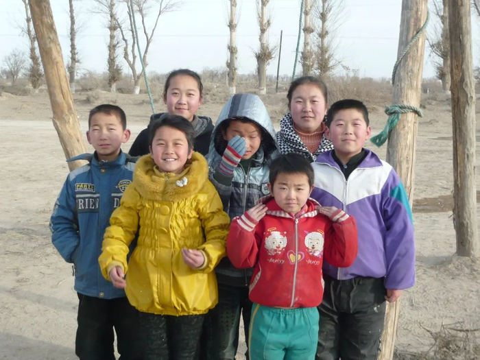 煌辉村的孩子们最后一次在村里的秋千下合影。王文明 摄