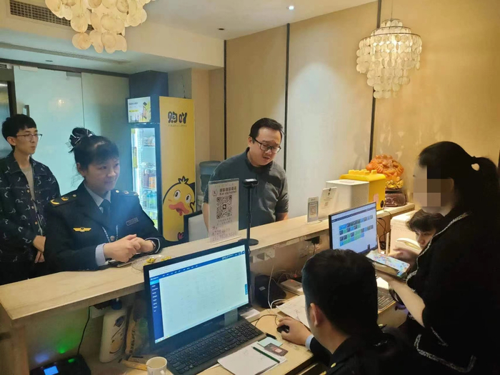 执法人员检查酒店“五一”期间房间的预订信息。