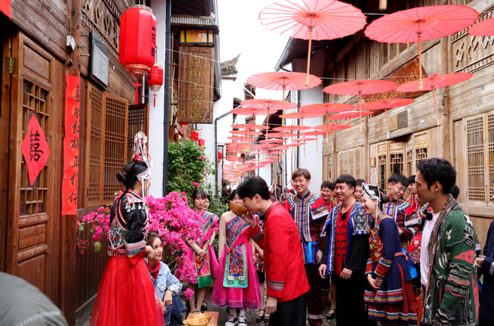 （图说：惊喜官袁弘和新人们一同体验畲族“长桌宴”）