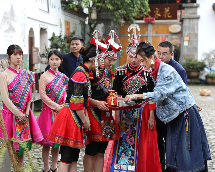 （图说：惊喜官张歆艺带领的“赤娘团”用红坛酒鬼酒“拦门”新郎）