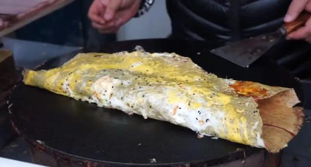 煎饼果子做好啦，准备开吃。截图出自微纪录片《天津传统煎饼果子》。