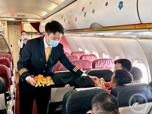 △扮演飞行员的乘务长李清配合主题航班活动环节为小朋友旅客送上零食