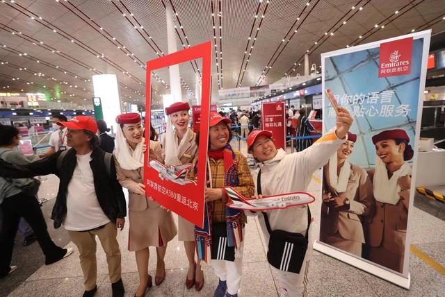5月1日21时许，搭载阿联酋航空EK307航班的旅客在首都机场合影。新京报记者 陶冉 摄