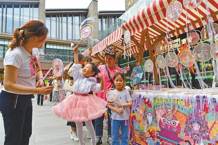 “五一”假期，陕西各大景区内的商品市场人气持续攀升。图为5月2日，游客在西安市易俗社文化街区选购小商品。记者 杜玮摄