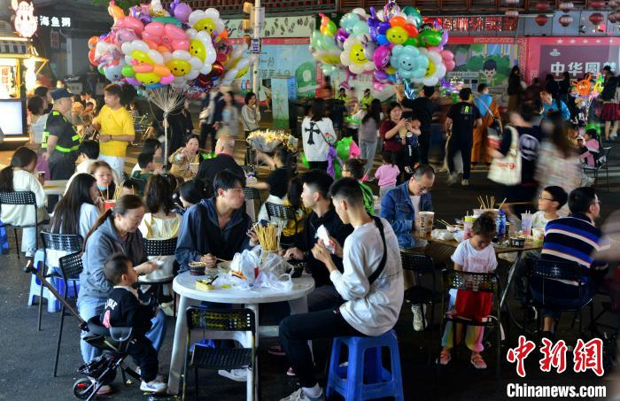 图为民众在福州市达明美食街品尝美食。张斌 摄