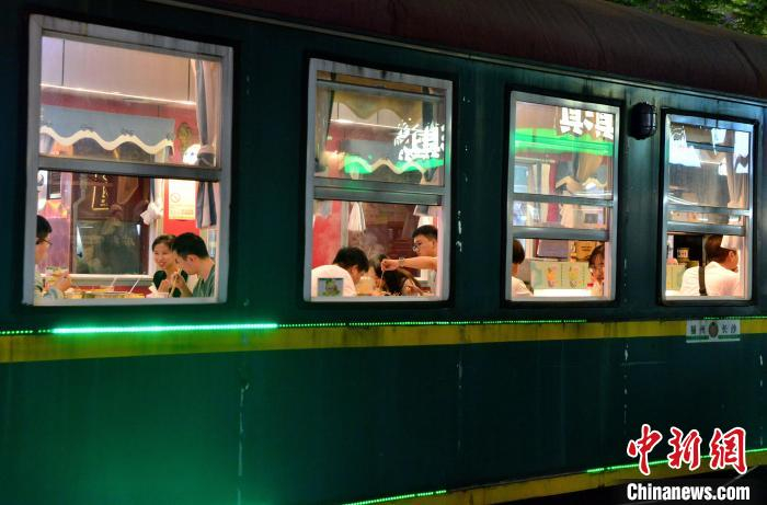 图为民众在福州市达明美食街“火车”餐厅内享受美食。张斌 摄