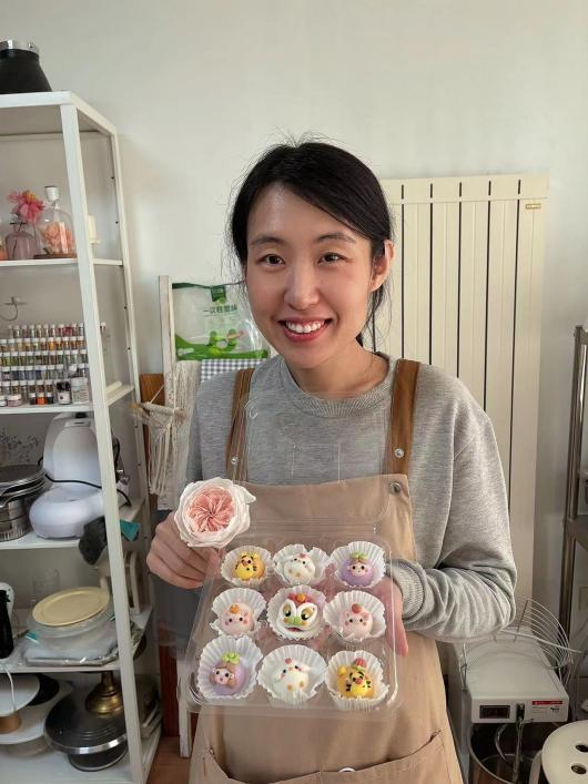 （手工馒头造型设计师安佳佳与其作品的合照）